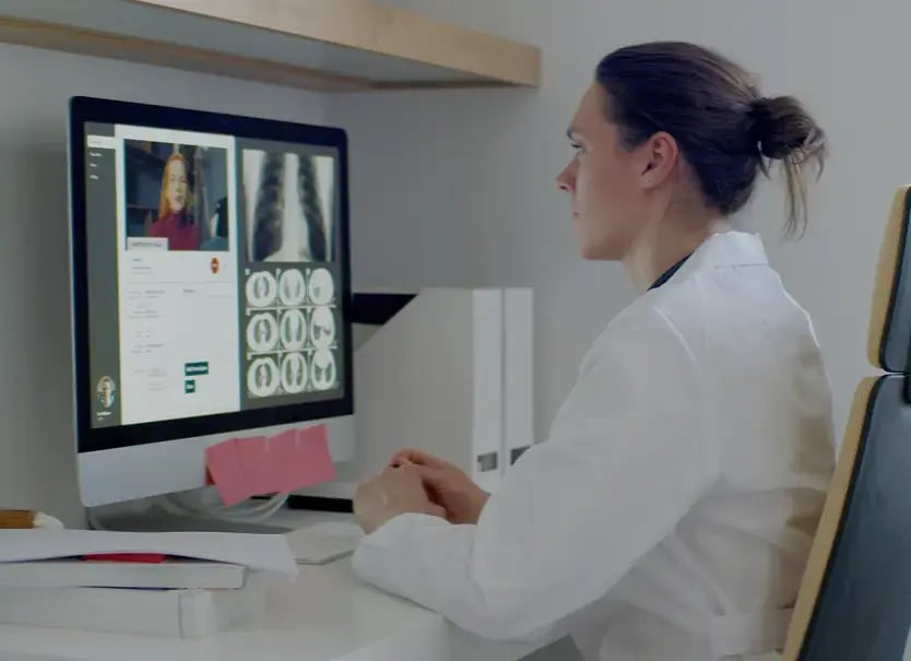Profesional de la salud realizando una consulta remota mientras revisa estudios radiológicos en pantalla, representando la autonomía tecnológica del servicio de radiología con Aquila+ de IMEXHS sin perder conectividad con sistemas existentes.